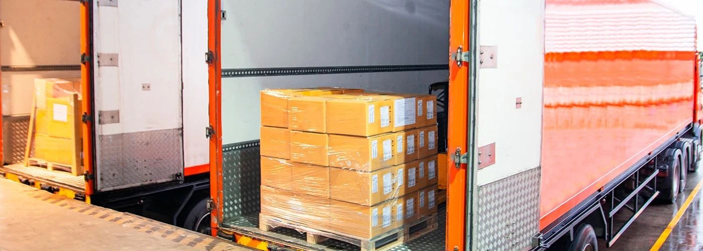 LTL freight shipping with wrapped pallets secured in a delivery truck